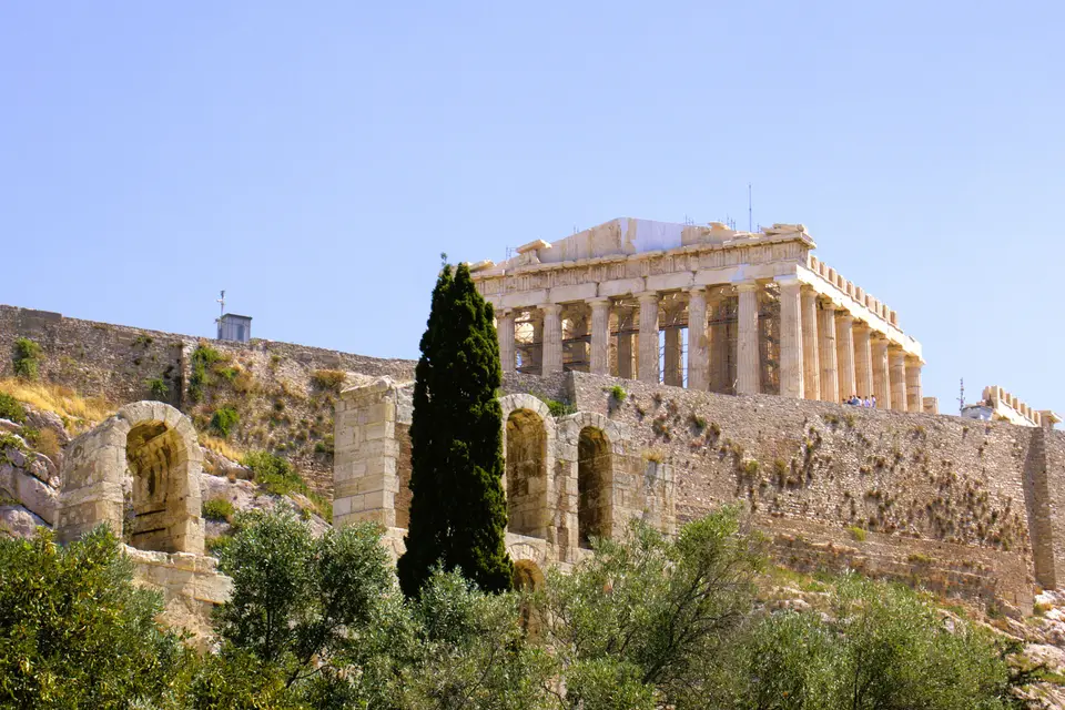 Akropolis kayalığı ve tepesindeki Parthenon, önde servi ve yeşillik