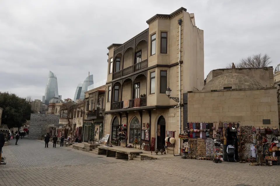 A historic street in Baku's Old City with the Flame Towers behind