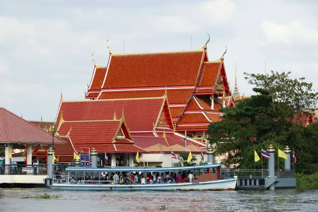 Chao Phraya Nehri'nde tapınak önünden geçen yolcu teknesi