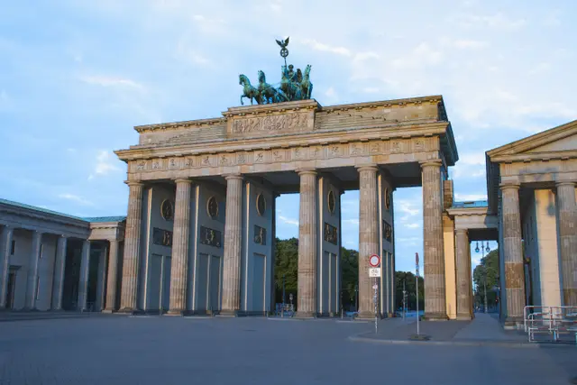 The columns of the Brandenburg Gate and the Quadriga on top under a clear sky