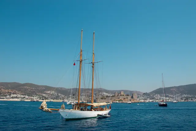 Denizden Bodrum Kalesi ve önünde iki direkli bir yelkenli