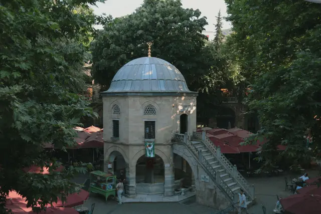 Koza Han'ın ağaçlı avlusu ve ortasındaki kubbeli küçük mescit