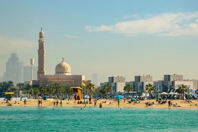 A palm-lined Dubai beach with the city skyline