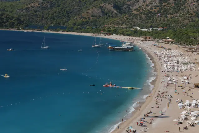 Ölüdeniz beach from above, with umbrellas and boats anchored in the bay