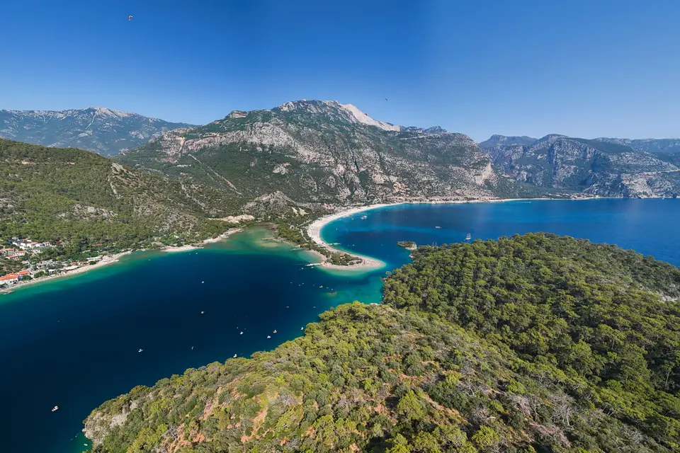 Havadan Ölüdeniz: turkuaz lagün, kumsal ve arkadaki dağlar