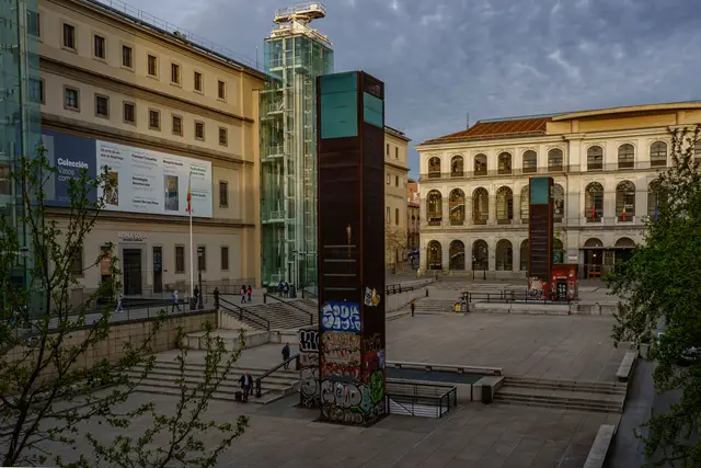 The entrance of the Reina Sofía Museum and its glass lift towers in the early evening