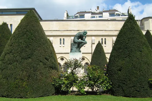 Musée Rodin bahçesinde budanmış ağaçlar arasında Düşünen Adam heykeli