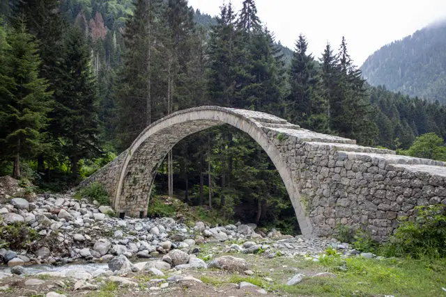 Rize'de ormanlı bir vadide dere yatağı üzerindeki tarihî taş kemer köprü