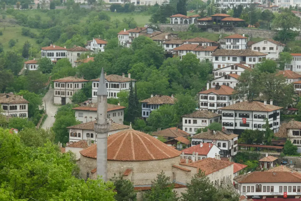 Yeşillikler arasında yamaca dizilen geleneksel Safranbolu evleri ve cami