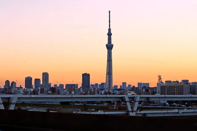 Gün batımında şehir siluetinin üzerinde yükselen Tokyo Skytree